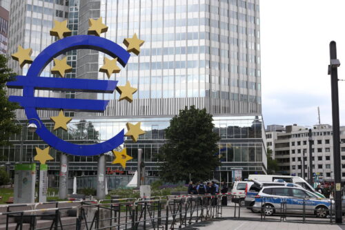 Großes Eurozeichen steht vor einem Bankenhochhaus in Frankfurt.