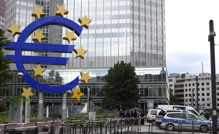Großes Eurozeichen steht vor einem Bankenhochhaus in Frankfurt.